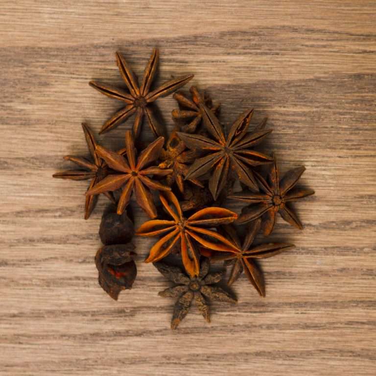 a group of star anise on a wood surface